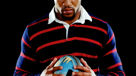 Angry-professional-rugby-sportsman-holds-a-rugby-ball-in-his-hands.