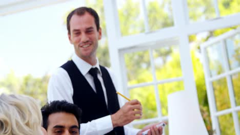 Smiling-waiter-interacting-with-customers