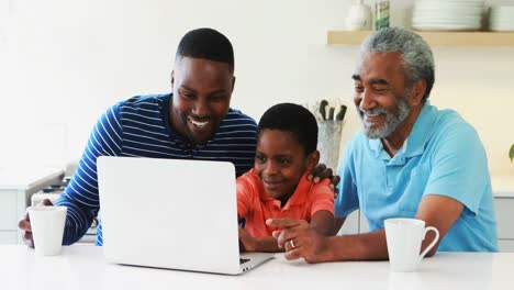 Multi-generation-family-using-laptop-in-kitchen