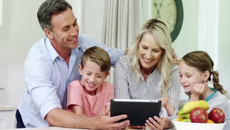 Lächelnde-Familie-Nutzt-Gemeinsam-Ein-Digitales-Tablet-Im-Wohnzimmer
