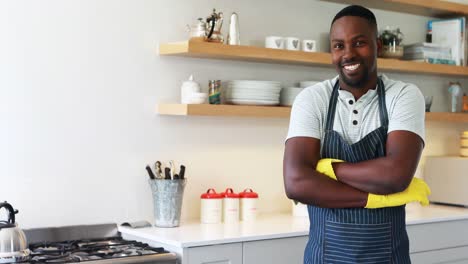 Smiling-man-standing-with-arms-crossed-in-kitchen