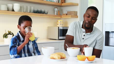 Father-and-son-having-breakfast-in-kitchen