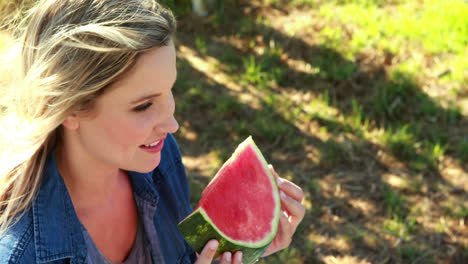 Beautiful-woman-having-watermelon-slice-in-park-4k