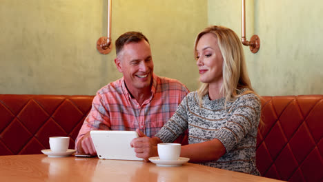 Couple-using-digital-tablet-while-having-coffee-4k