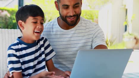 Father-and-son-using-laptop-4k