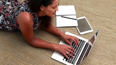 Weibliche-Führungskraft-Benutzt-Laptop,-Während-Sie-Auf-Dem-Teppich-Liegt-4K