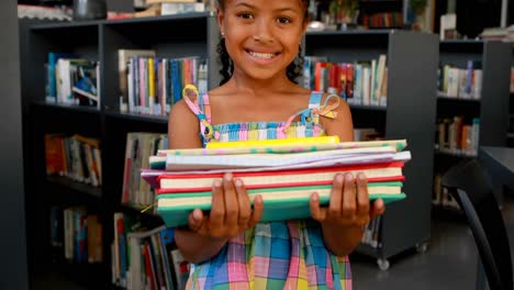 Portrait-of-happy-schoolgirl-standing-with-book-stack-4k