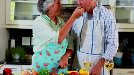 Senior-couple-cutting-vegetables-in-kitchen-4k