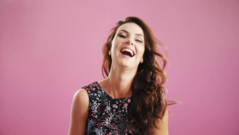 Smiling-woman-waving-hair-against-pink-background-4k