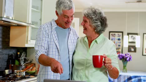 Senior-couple-using-laptop-while-having-coffee-4k