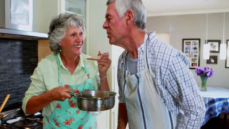 Senior-couple-tasting-food-cooking-in-kitchen-4k