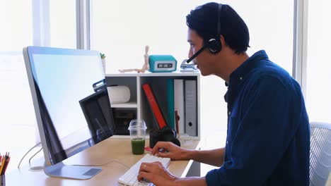 Männlicher-Leitender-Angestellter-Im-Headset,-Der-An-Seinem-Schreibtisch-Am-Computer-Arbeitet-4k