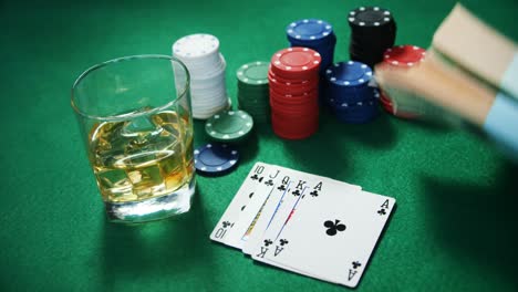 Playing-cards,-casino-chips,-bundle-of-us-dollar-and-glass-of-beer-on-poker-table-4k