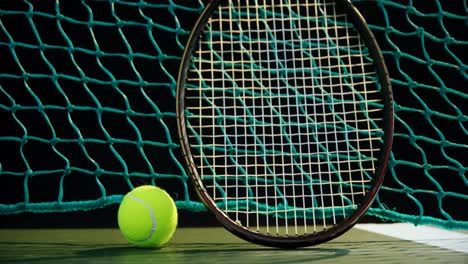 Tennis-ball-and-racket-against-net-in-court-4k