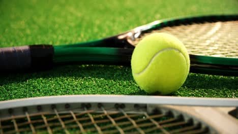 Close-up-of-tennis-ball-and-rackets-arranged-on-grass-4k