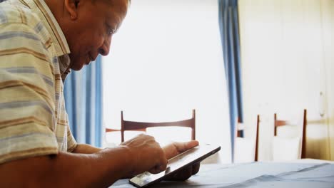 Senior-man-using-digital-tablet-at-table-4k