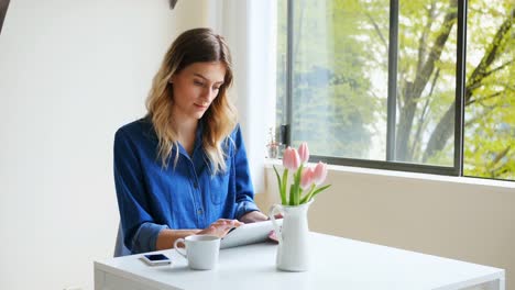 Woman-using-digital-tablet-while-having-coffee-4k