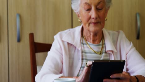 Senior-woman-using-digital-tablet-at-table-4k