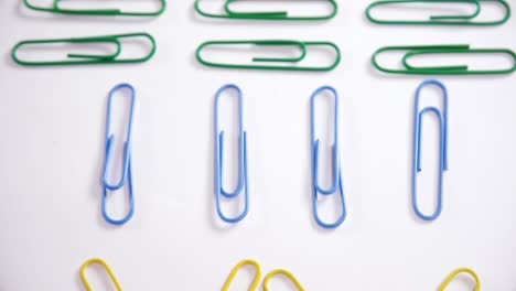 Colorful-paper-clips-arranged-on-white-background-4k
