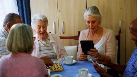 Senioren-Nutzen-Mobiltelefon-Und-Digitales-Tablet,-Während-Sie-4K-Schach-Spielen