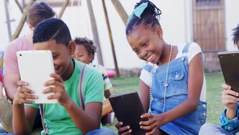 Niños-Usando-Tableta-Digital-En-El-Patio-Trasero-De-La-Casa-4k