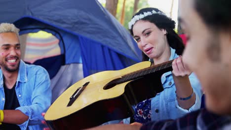 Woman-passing-guitar-to-her-friends-at-music-festival-4k
