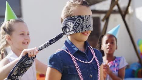 Girl-tying-blindfold-on-friend-4k