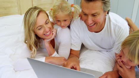 Family-using-laptop-together-in-bedroom-4k