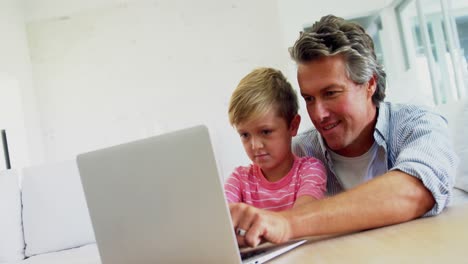 Vater-Und-Sohn-Benutzen-Laptop-Im-Wohnzimmer-4K