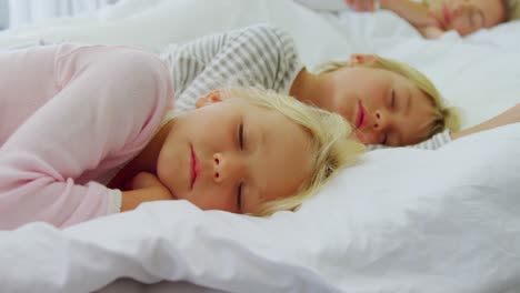 Kinder-Schlafen-Im-Bett,-Während-Die-Eltern-Im-Hintergrund-Schlafen,-4k