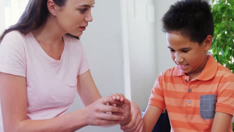 Female-physiotherapist-giving-hand-massage-to-boy-patient-4k