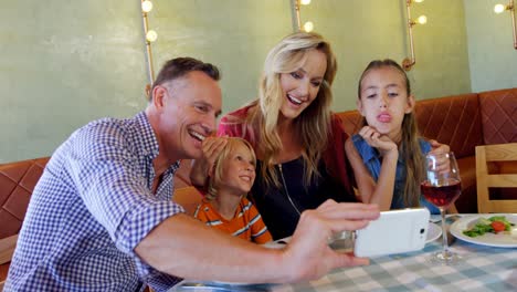Familie-Macht-Selfie-Mit-Mobiltelefon-Im-Restaurant-4k