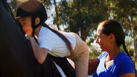 Mother-assisting-daughter-during-horse-riding-4k