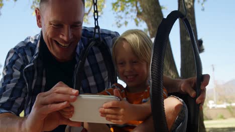 Father-and-son-using-digital-tablet-at-playground-4k