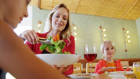 Mother-serving-salad-to-her-daughter-in-restaurant-4k