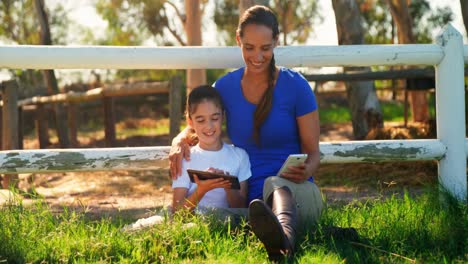 Mother-and-daughter-using-digital-tablet-and-mobile-phone-in-ranch-4k
