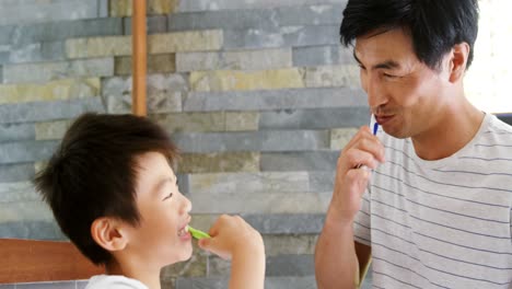 Father-and-son-brushing-teeth-together-in-bathroom-4k