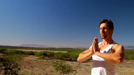 Man-performing-yoga-at-safari-vacation-4k