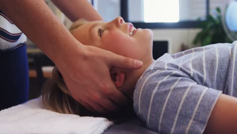 Physiotherapist-giving-head-massage-to-a-boy-4k