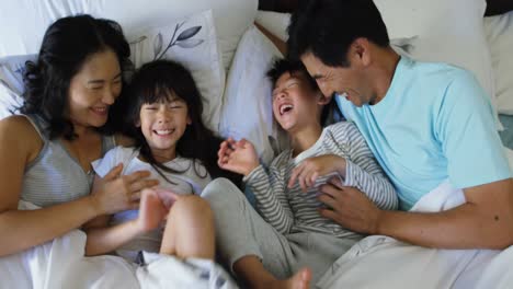 Familia-Feliz-Divirtiéndose-En-La-Cama-En-El-Dormitorio-4k