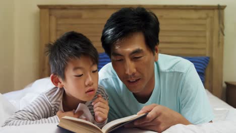 Vater-Und-Sohn-Lesen-Ein-Buch-Im-Schlafzimmer-4k