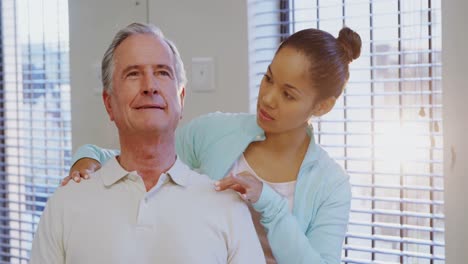 Physiotherapist-giving-shoulder-massage-to-senior-patient-4k