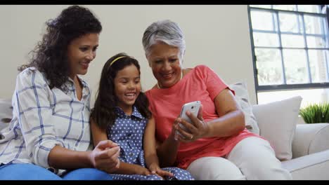 Mädchen-Mit-Mutter-Und-Großmutter,-Die-Das-Mobiltelefon-Anlächeln-4k-4k