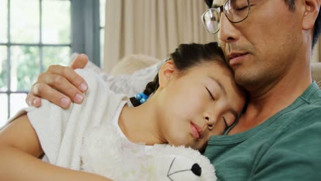 Father-and-daughter-relaxing-on-sofa-in-living-room-4k