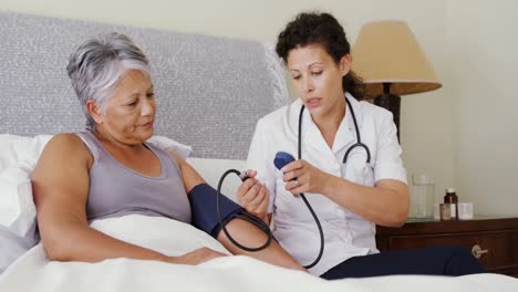 Female-doctor-measuring-blood-pressure-of-a-senior-woman-4k