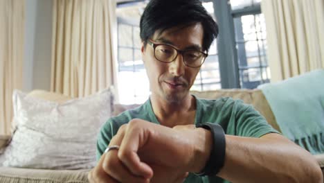 Man-using-smart-watch-in-living-room-4k