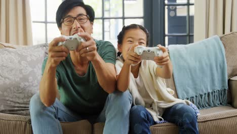 Father-and-daughter-playing-video-game-in-living-room-4k