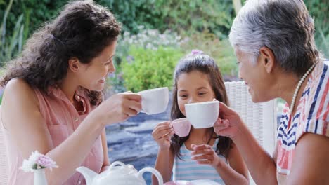 Mother,-daughter-and-granny-toasting-the-tea-cups-in-the-garden-4K-4k