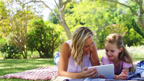 Happy-mother-and-daughter-using-digital-tablet-in-park-4k