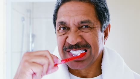 Senior-man-brushing-teeth-in-bathroom-4k
